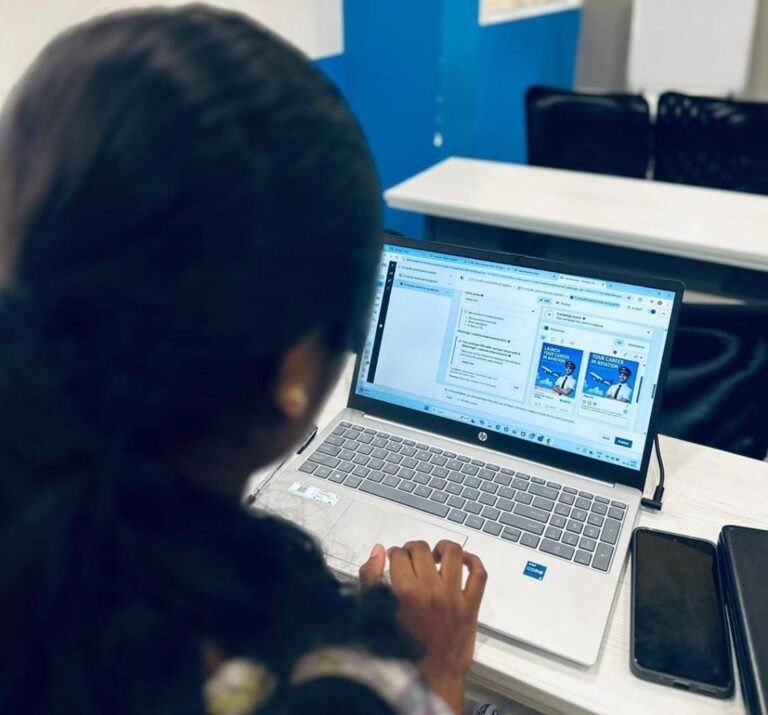 Digital marketing strategist in Kerala sitting at a desk, working on a laptop with a digital marketing dashboard open on the screen, reviewing campaign content and analytics, with a smartphone placed beside the laptop in a quiet workspace
